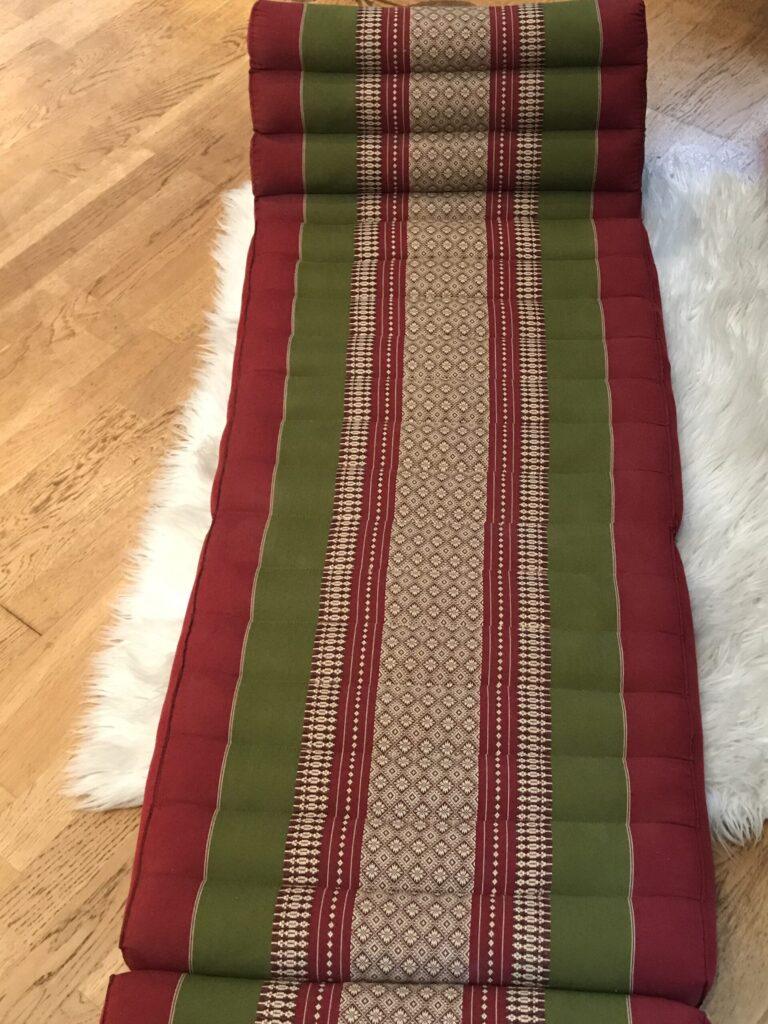 A traditional woven textile with red, green, and beige stripes.