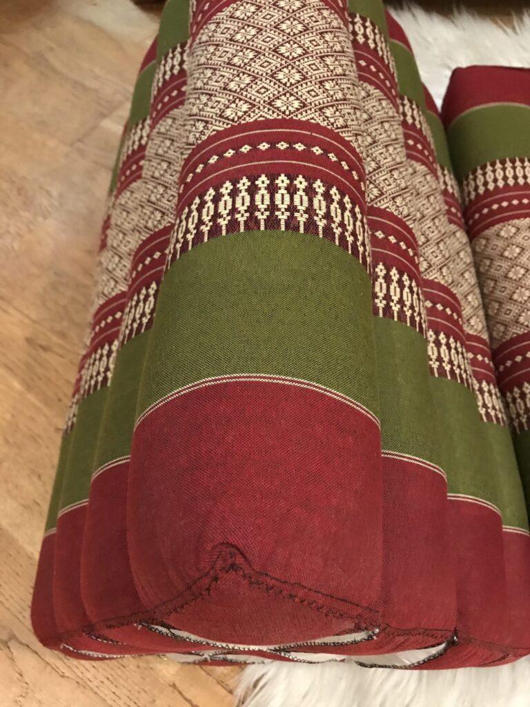 Fabric with red, green, and cream traditional patterns.