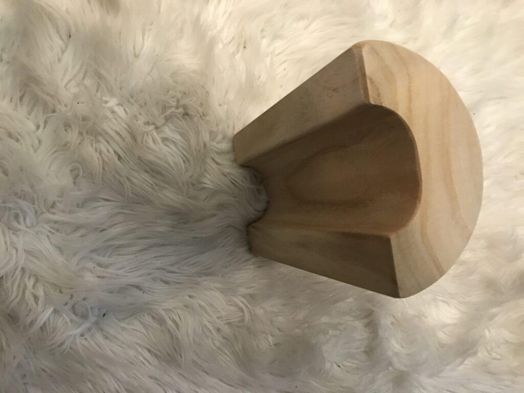 Smooth wooden object with rounded edges on a soft fur surface.